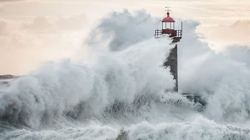 Огромная волна разбивается о маяк в Порту, Португалия